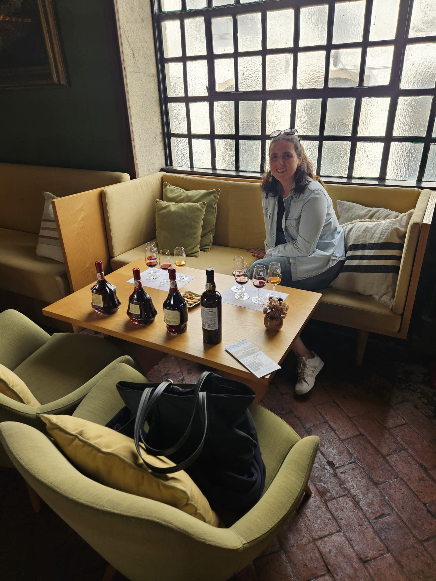 Lívia Belfort sentada junto à mesa de degustação de Vinhos do Porto